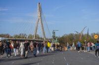 Przechodnie w Warszawie, przy Pomniku Syrenki nad Wisłą. W tle Most Świętokrzyski