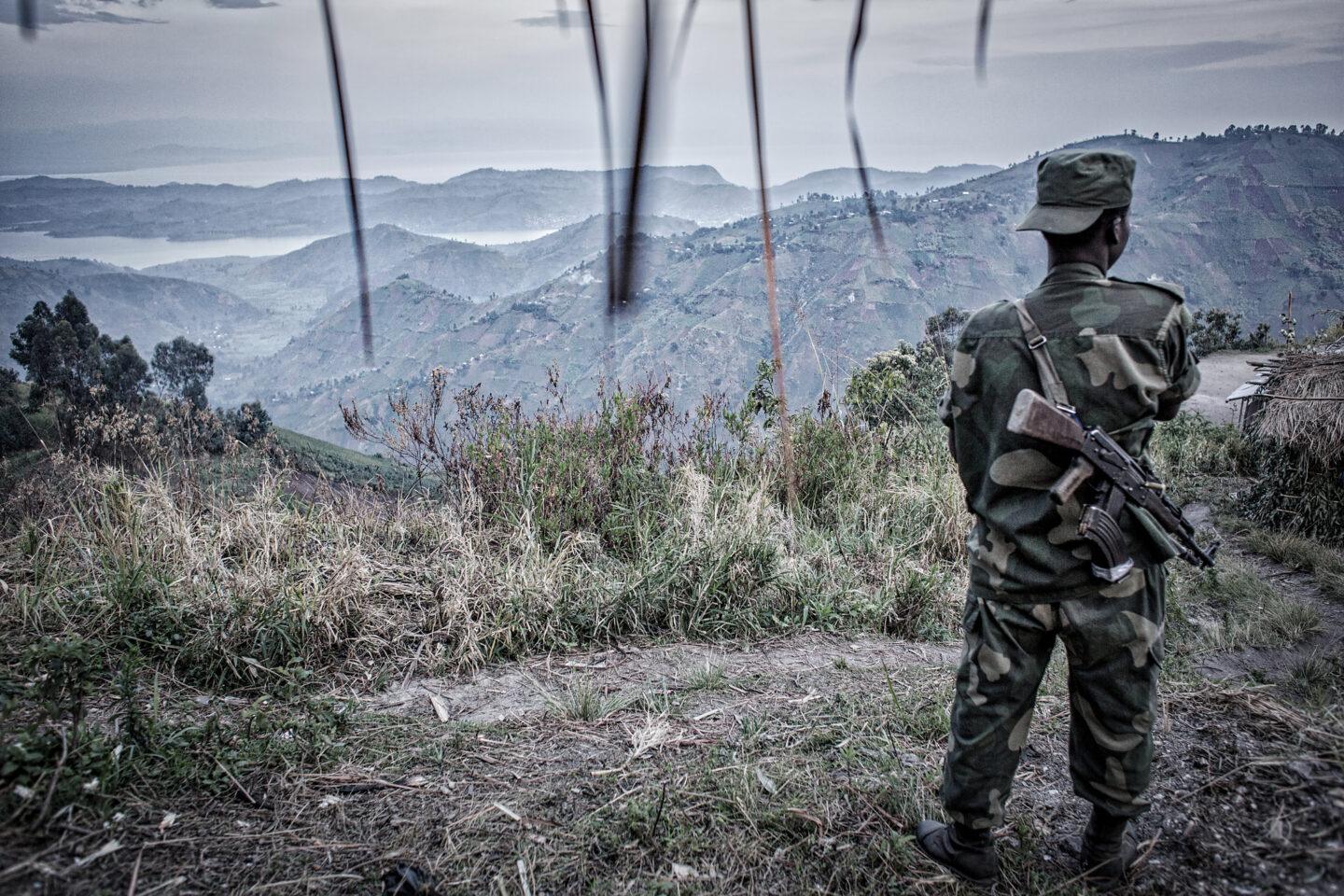 Na zdjęciu żołnierz patrzy ze wzgórza na dolinę w Afryce