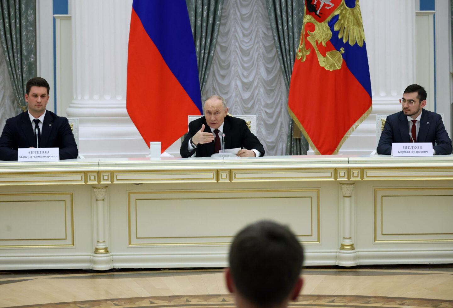 Przywódca Rosji Władimir Putin, za nim flaga Rosji
