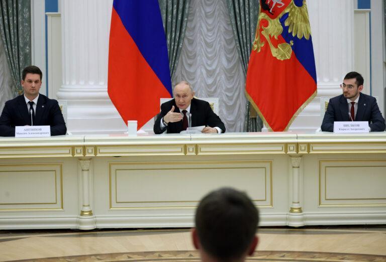 Przywódca Rosji Władimir Putin, za nim flaga Rosji