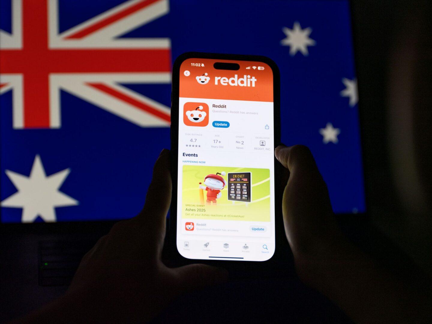 Na zdjęciu: Telefon z uruchomionym serwisem reddit na tle flagi Australii
