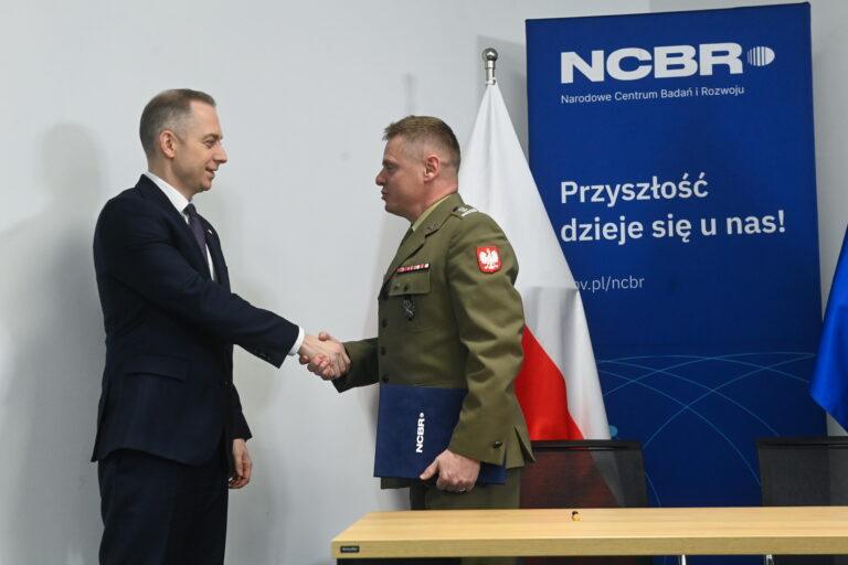 Wiceminister obrony narodowej Cezary Tomczyk (z lewej) i dyrektor Wojskowego Instytutu Technicznego Uzbrojeniana płk dr inż. Paweł Sweklej (z prawej) na konferencji prasowej w siedzibie NCBR w Warszawie
