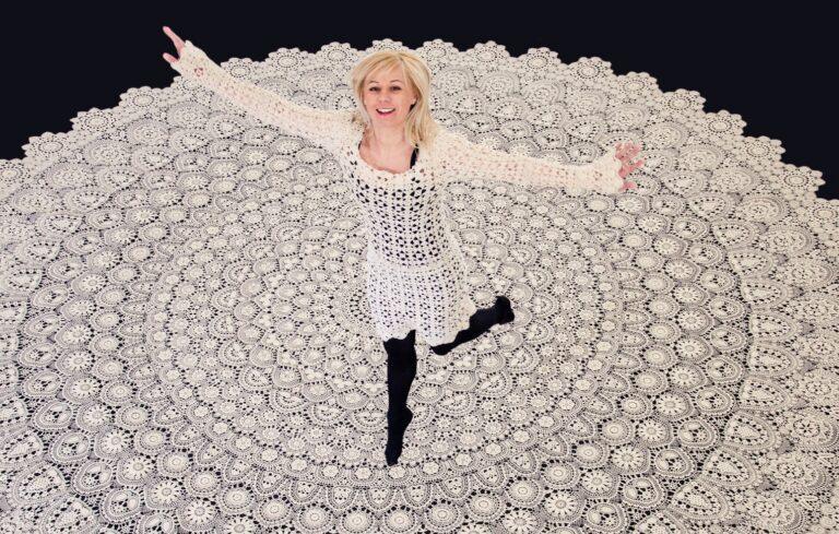 Lucyna Ligocka-Kohut, założycielka Centrum Koronki Koniakowskiej, na tle koronki koniakowskiej, która została wpisana do Księgi Rekordów Guinnessa.