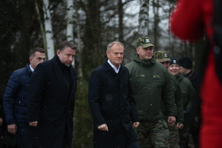 Premier Donald Tusk (w środku), minister spraw wewnętrznych i administracji Marcin Kierwiñski, (drugi z lewej) oraz komendant główny Straży Granicznej gen. dyw. SG Robert Bagan (w środku z prawej) przed rozpoczeciem konferencji prasowej na granicy polsko-białoruskiej. Ozierany Wielkie