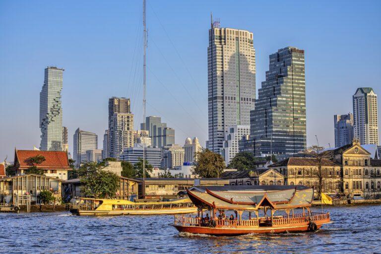 Łodzie płynące po rzece na tle wieżowców