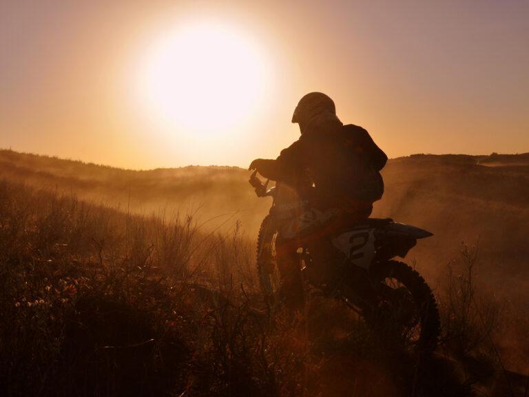 Motocykl na pustyni na tle zachodzącego słońca