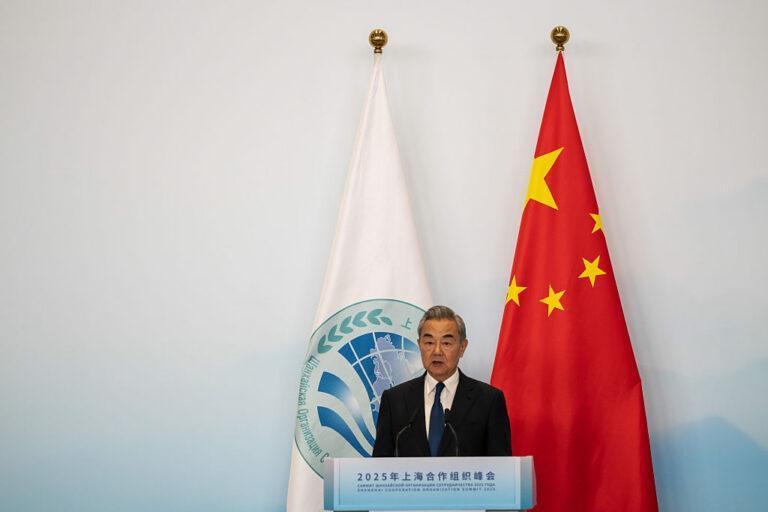 Wangi Yi na tle chińskiej flagi