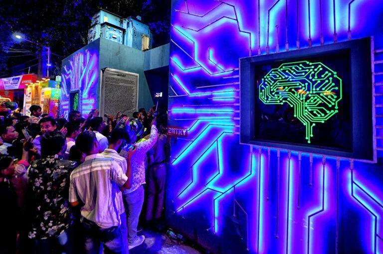 Grupa osób przed neonową instalacją przedstawiającą ludzki mózg i układy scalone