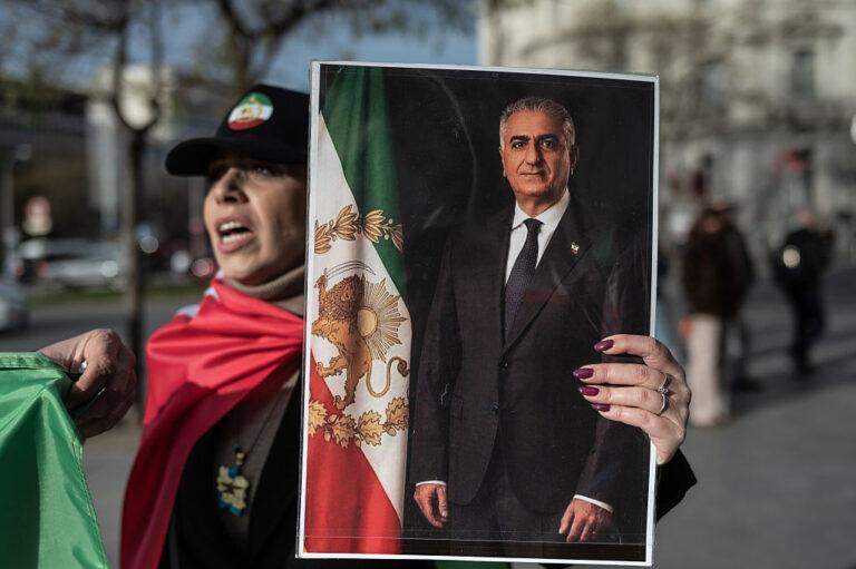 Protestująca kobieta trzyma zdjęcie Rezy Pahlawiego