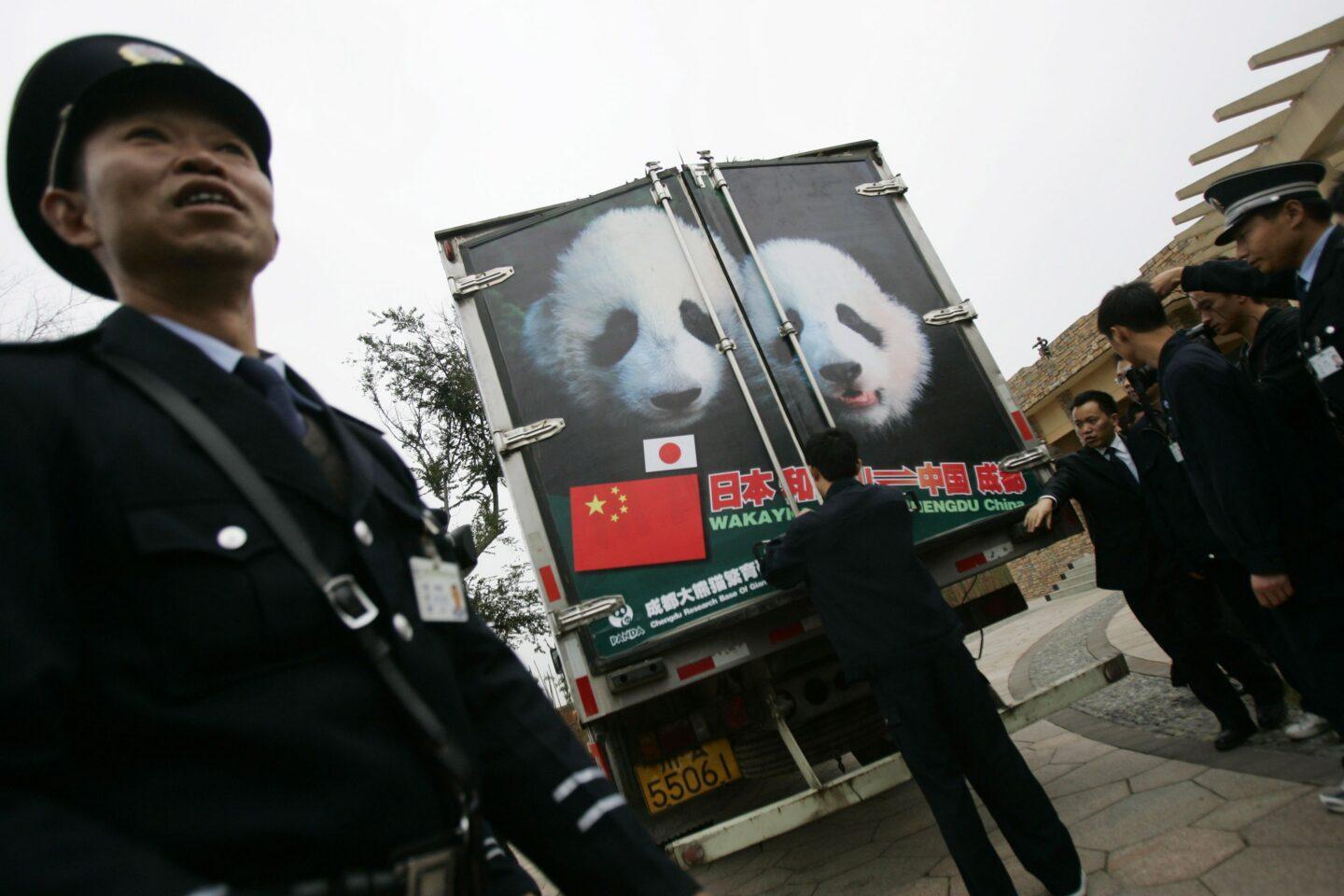 Umundurowany strażnik przed ciężarówką z wizerunkiem pand