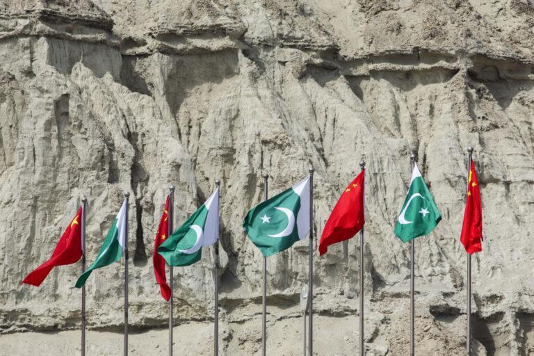 Flagi Pakistanu i Chin na tle otoczenia portu Gwadar