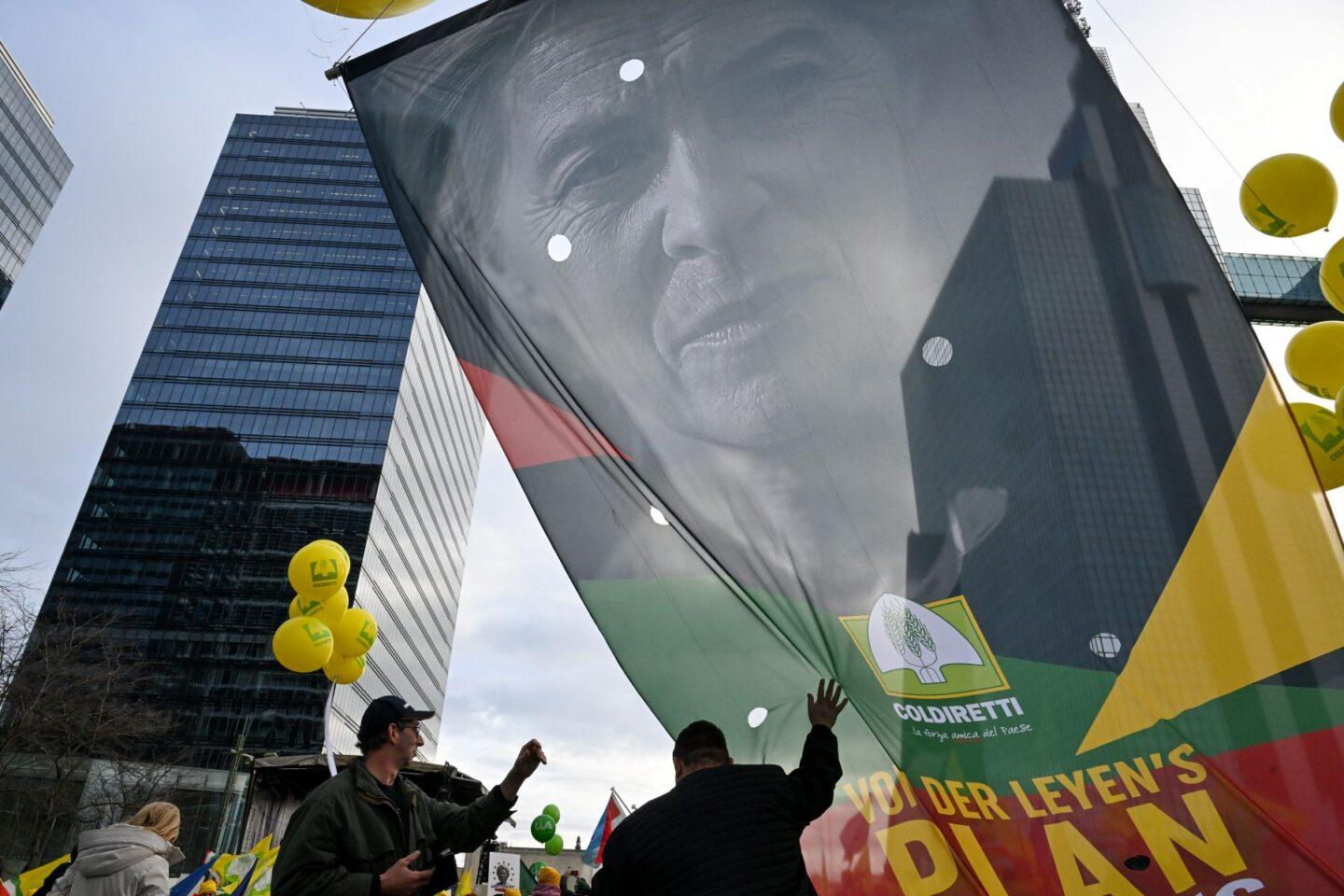 Rolnicy niosą ogromny baner z wizerunkiem Ursuli von der Leyen, przewodniczącej Komisji Europejskiej, podczas protestu przeciwko umowie z Mercosurem w Brukseli, w Belgii
