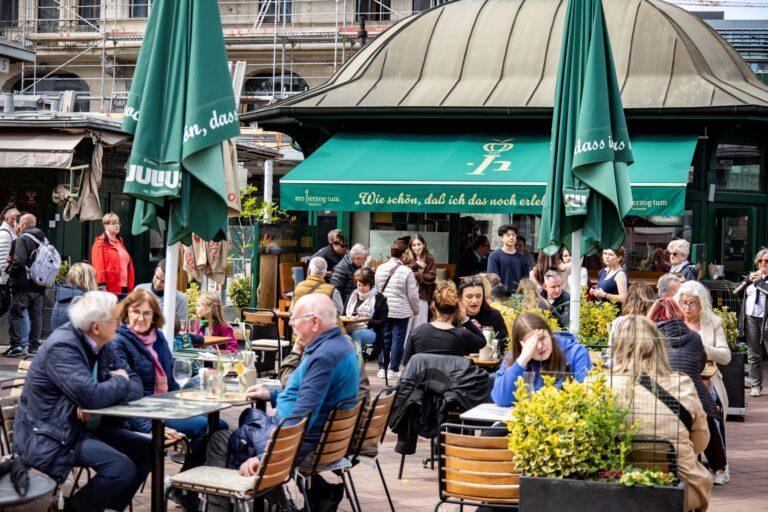 Osoby siedzące w ogródku kawiarni w Wiedniu