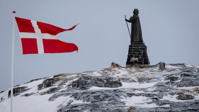 Duńska flaga na tle pomnika Hansa Egede w grenlandzkim Nuuk