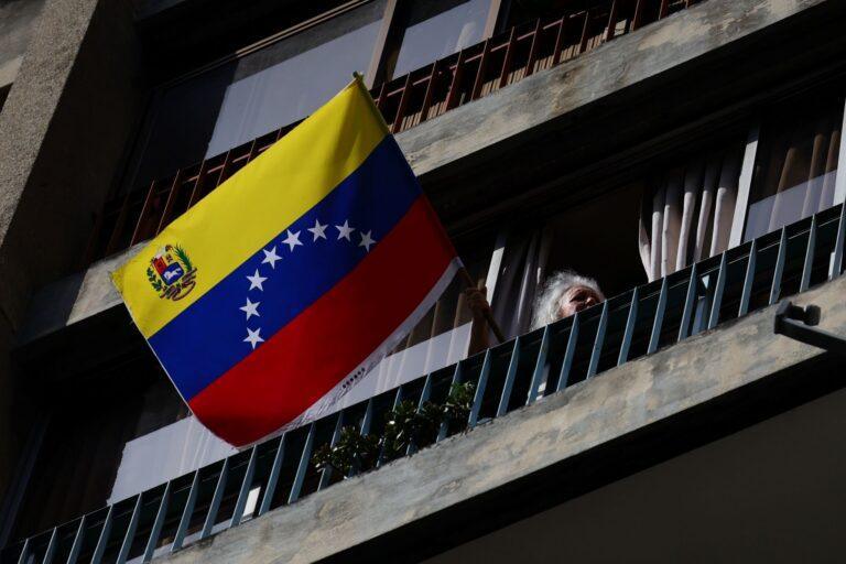 Kobieta trzymająca flagę Wenezueli podczas protestu zwolenników Nicolasa Maduro po jego uprowadzeniu przez USA