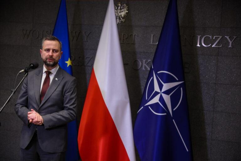 Władysław Kosiniak-Kamysz na tle flag Polski i NATO