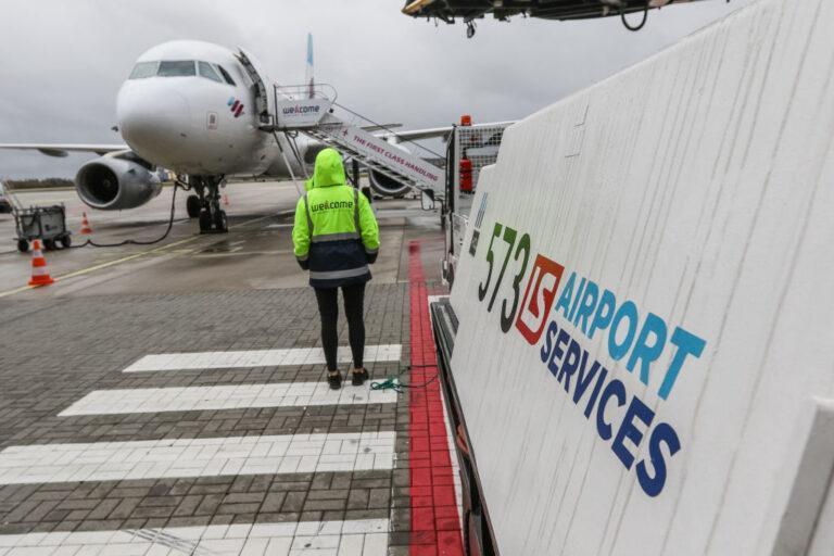 Pracownica obsługi na płycie przed samolotem