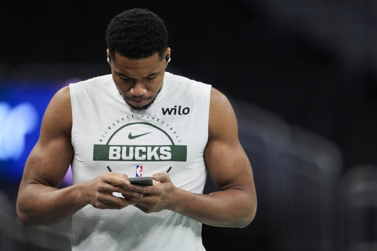 Giannis Antetokounmpo klikający na swoim smartfonie