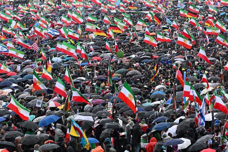 Ludzie z flagami Iranu w trakcie wiecu poparcia w Monachium