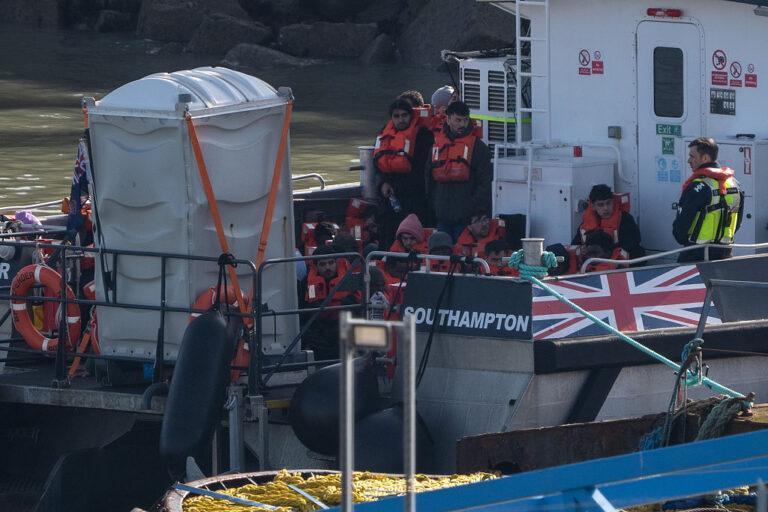 Migranci na łodzi w brytyjskim porcie