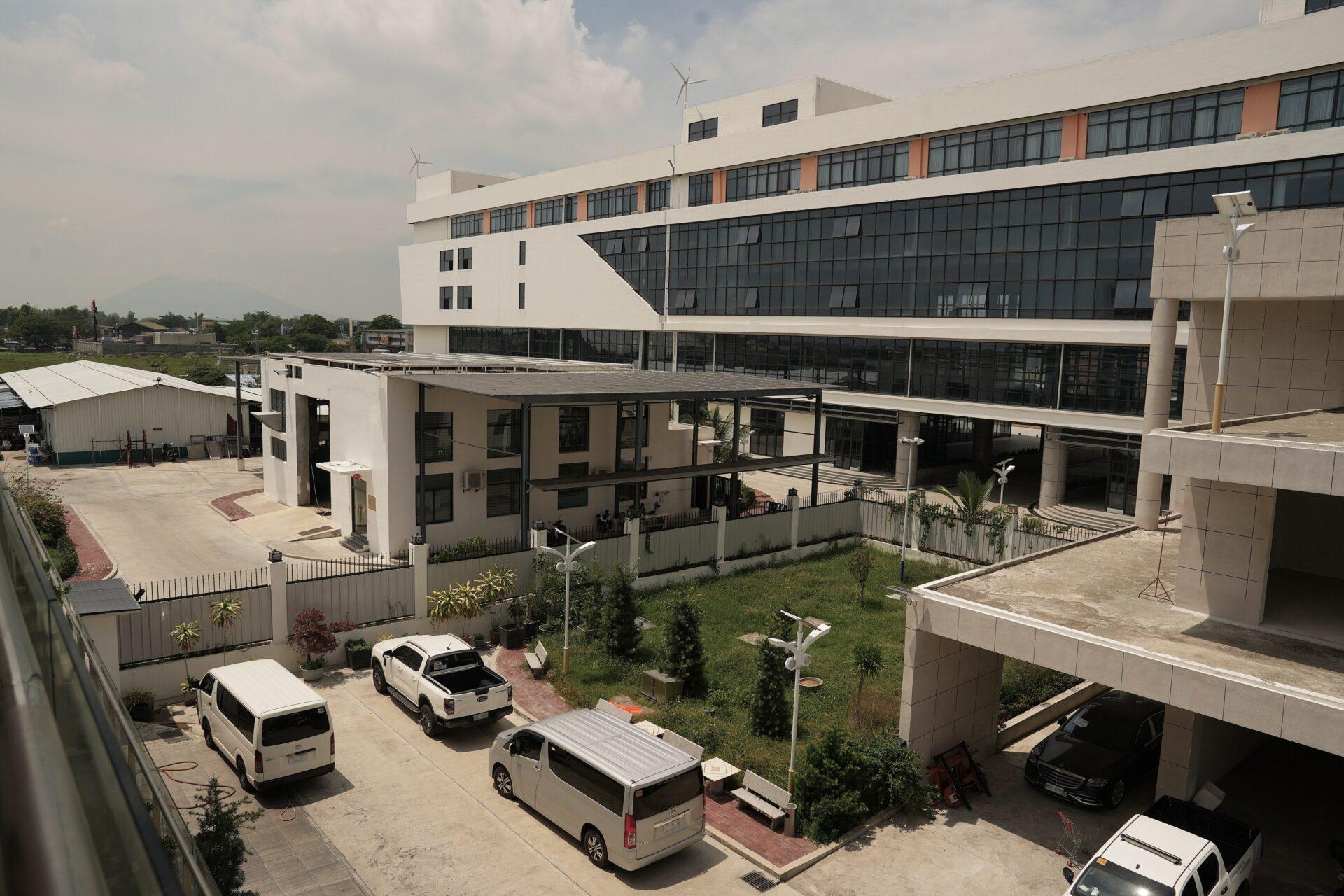 Budynki o charakterze biurowo-przemysłowym, na pierwszym planie stoją furgonetki