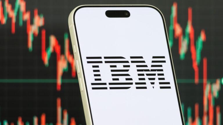 Logo IBM na tle wykresów giełdowych