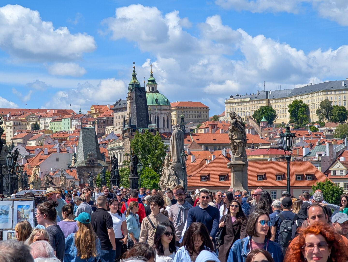 Tłum turystów na Moście Karola nad Wełtawą w Pradze.