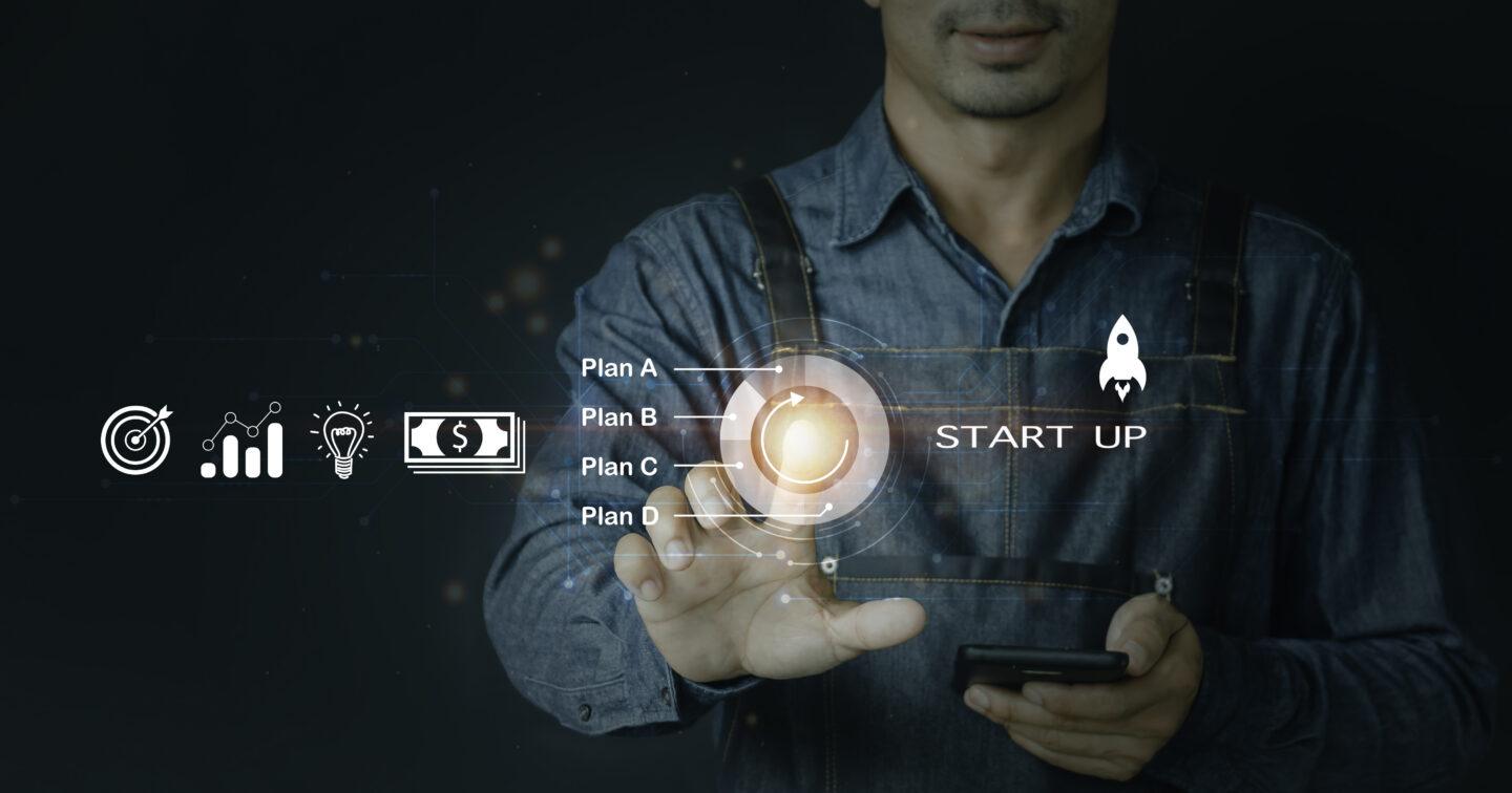 Osoba dotykająca ręką ekranu z napisem start up