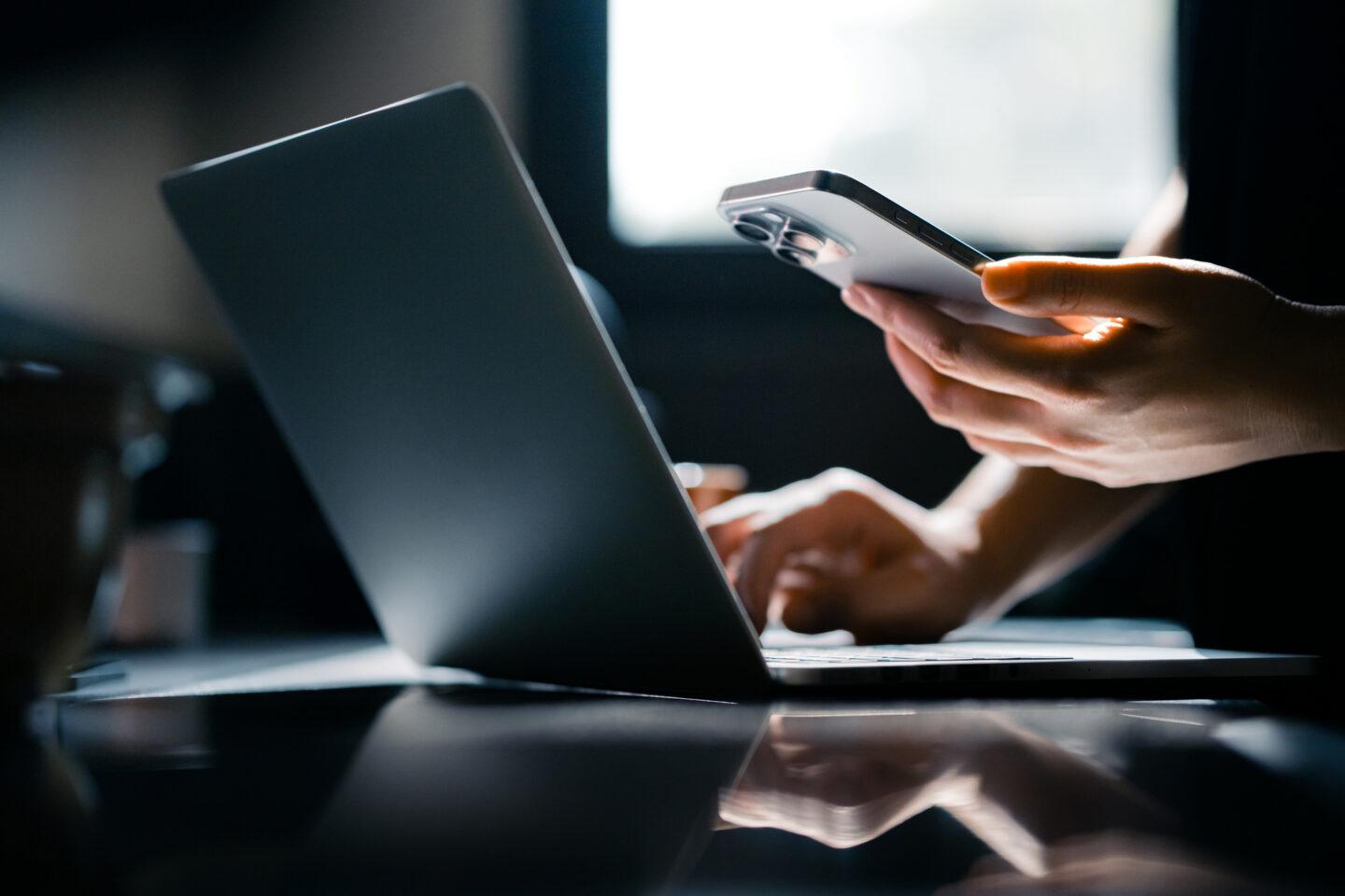 Laptop i smartfon w trakcie robienia przelewu w sieci
