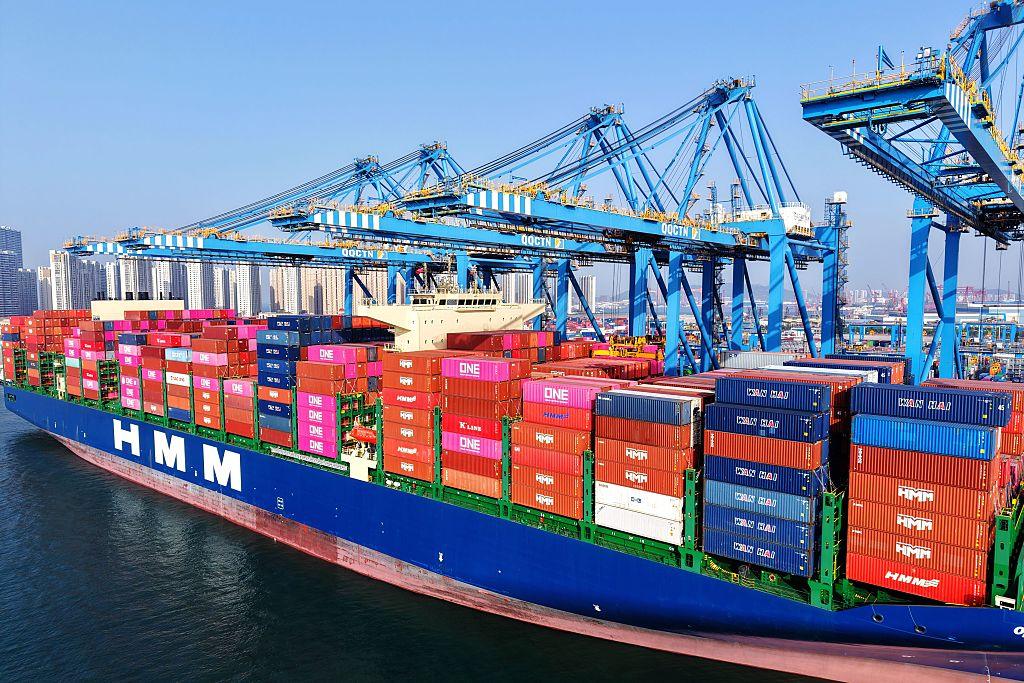 Kontenerowiec w porcie z widoczną infrastrukturą załadunkową