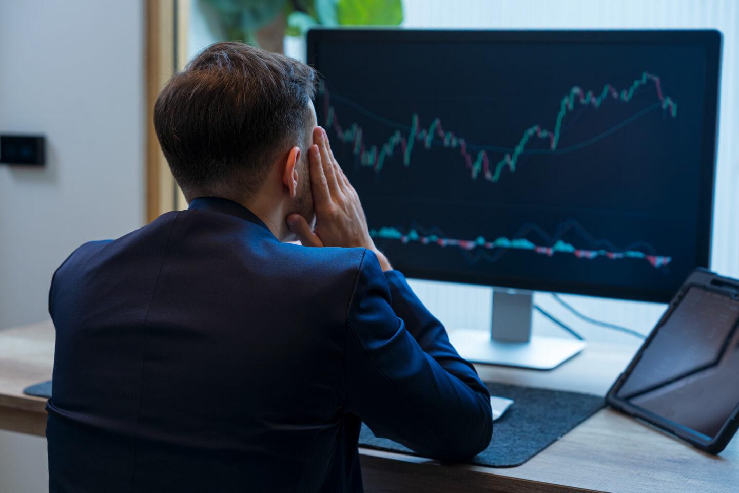 Zestresowany inwestor patrzy na wykres