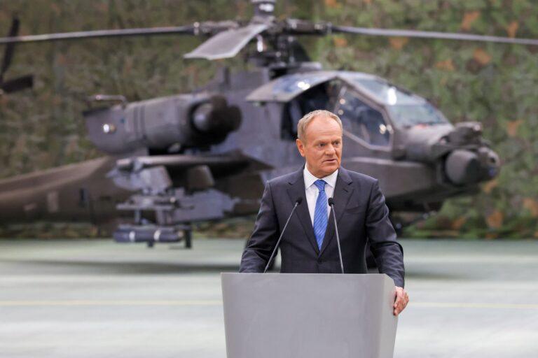 Premier Donald Tusk na tle śmigłowca AH-64E Apache