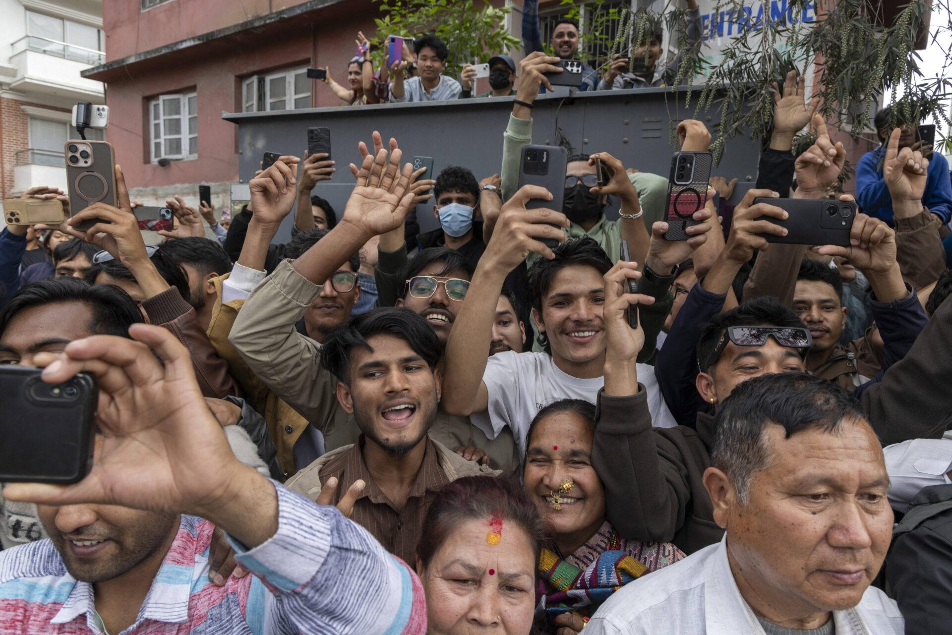 Grupa osób robi zdjęcia smartfonami