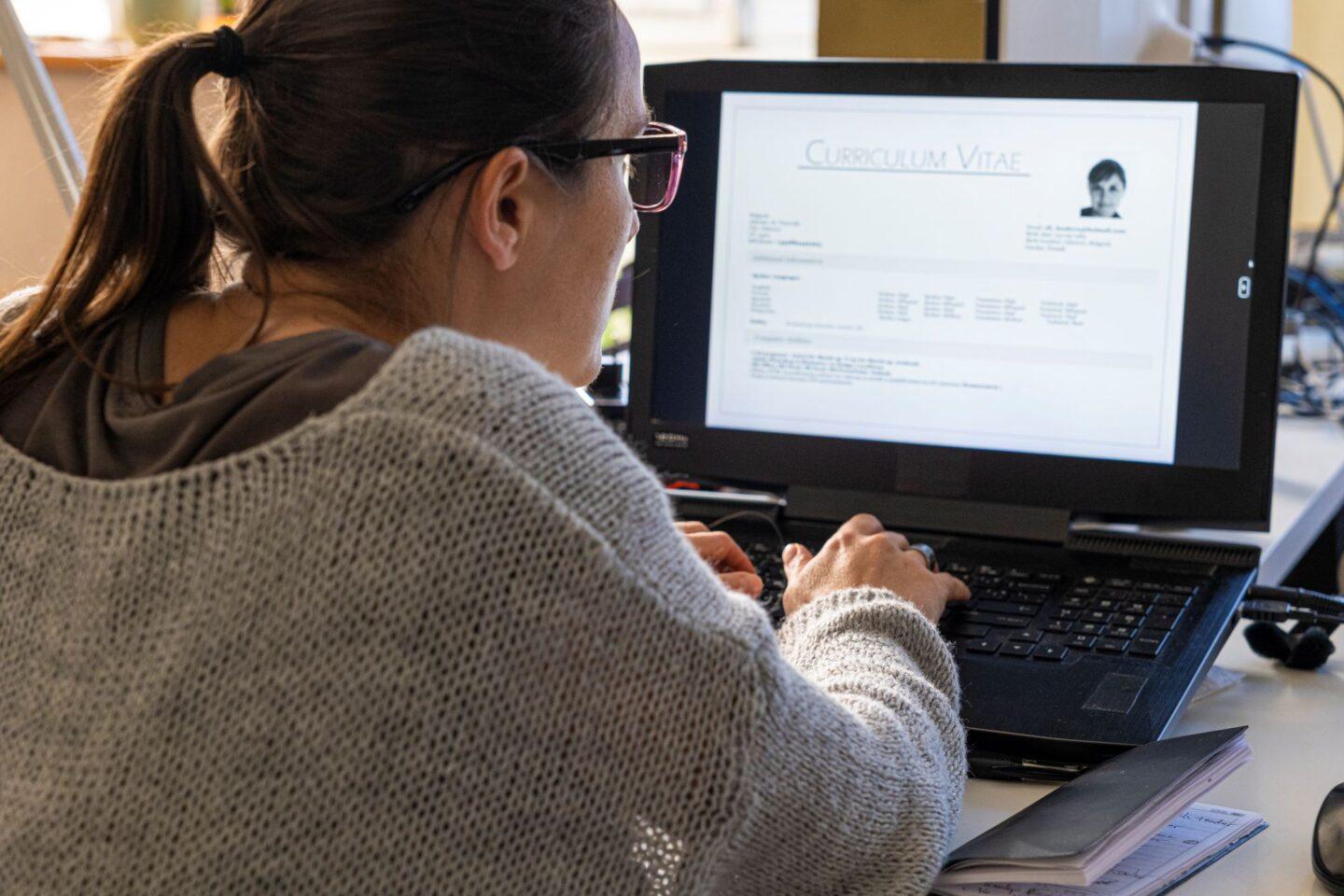 Kobieta przeglądająca CV na ekranie komputera