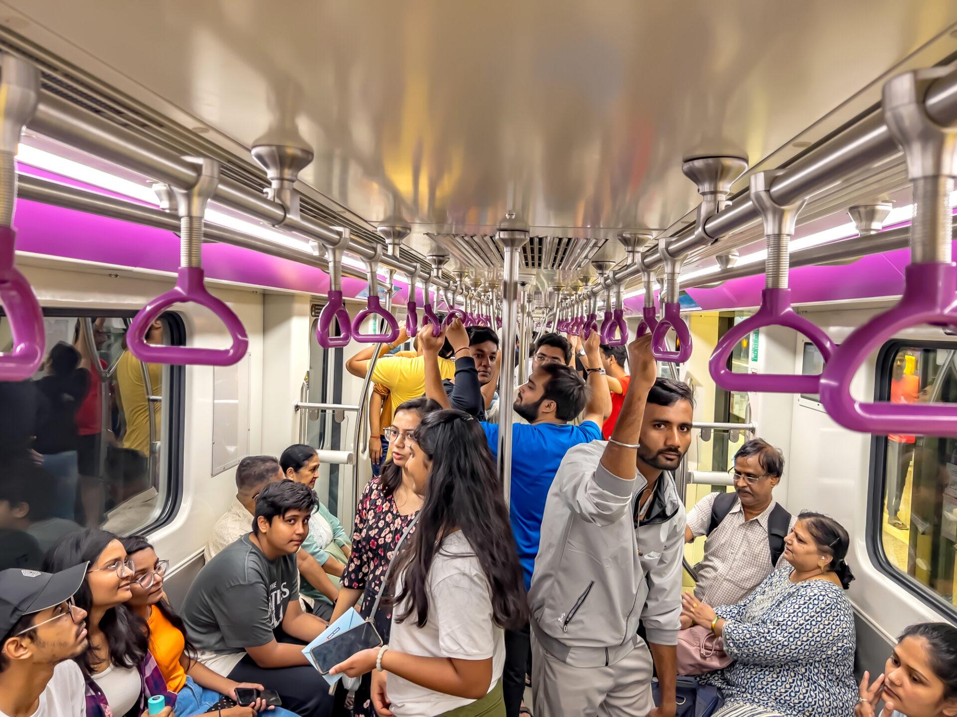 Grupa osób wewnątrz wagonu metra w Indiach