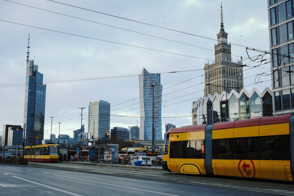 Trams pass the Palace of Culture and Science, right, and skyscraper office buildings in downtown Warsaw, Poland, on Friday, Dec. 22, 2023. The central bank halted interest rate cuts after the Oct. 15 parliamentary election unexpectedly brought the pro-European Union opposition to power, along with their promises to boost budget spending. Photographer: Damian Lemaski/Bloomberg via Getty Images