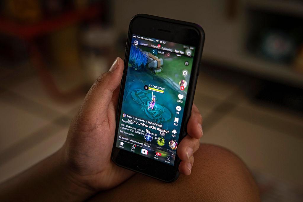 Ręka dziecka trzymającego smartfon z wyświetloną na ekranie grą