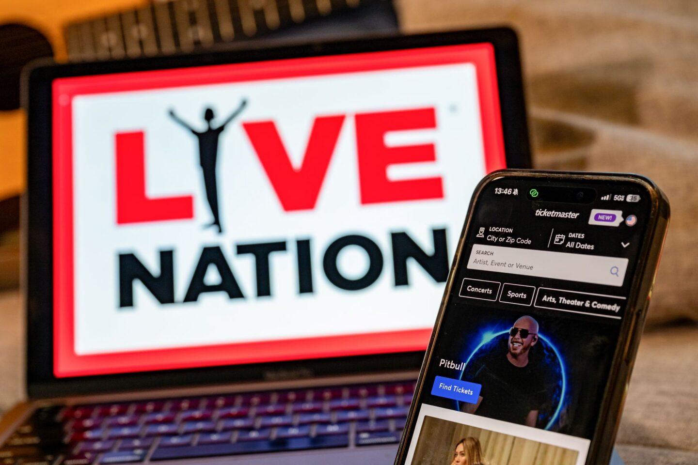 Smartfon z logo platformy Ticketmaster na tle ekranu z logo Live Nation