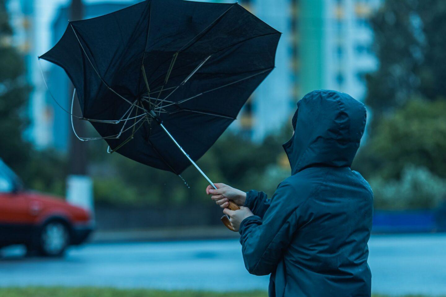 Mężczyzna z parasolką w silnym wietrze