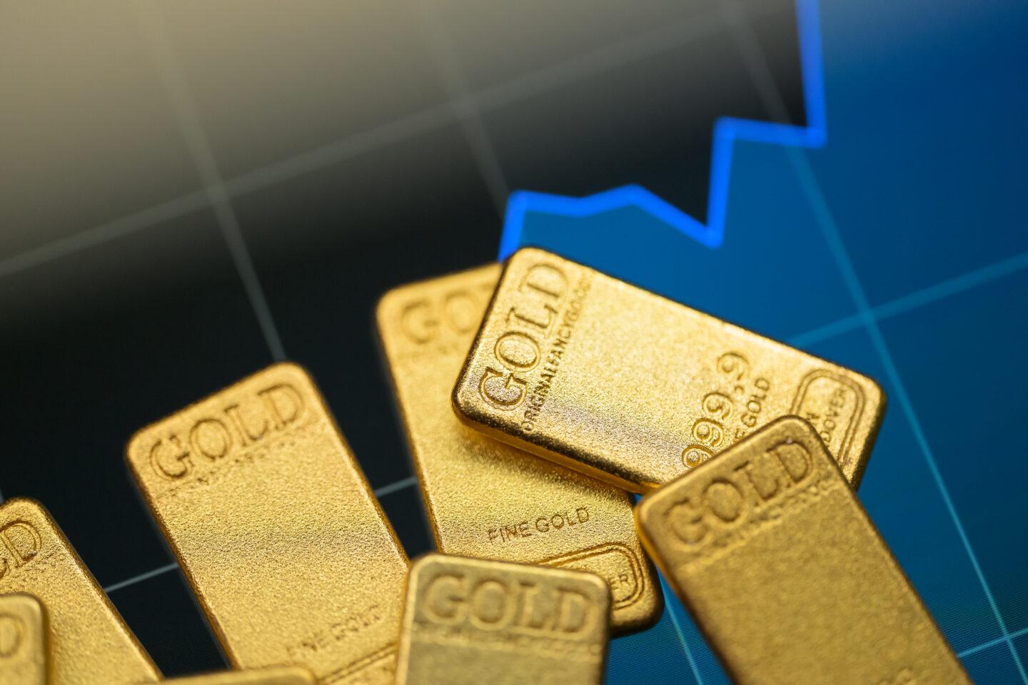 Sztabki złota na tle wykresu.