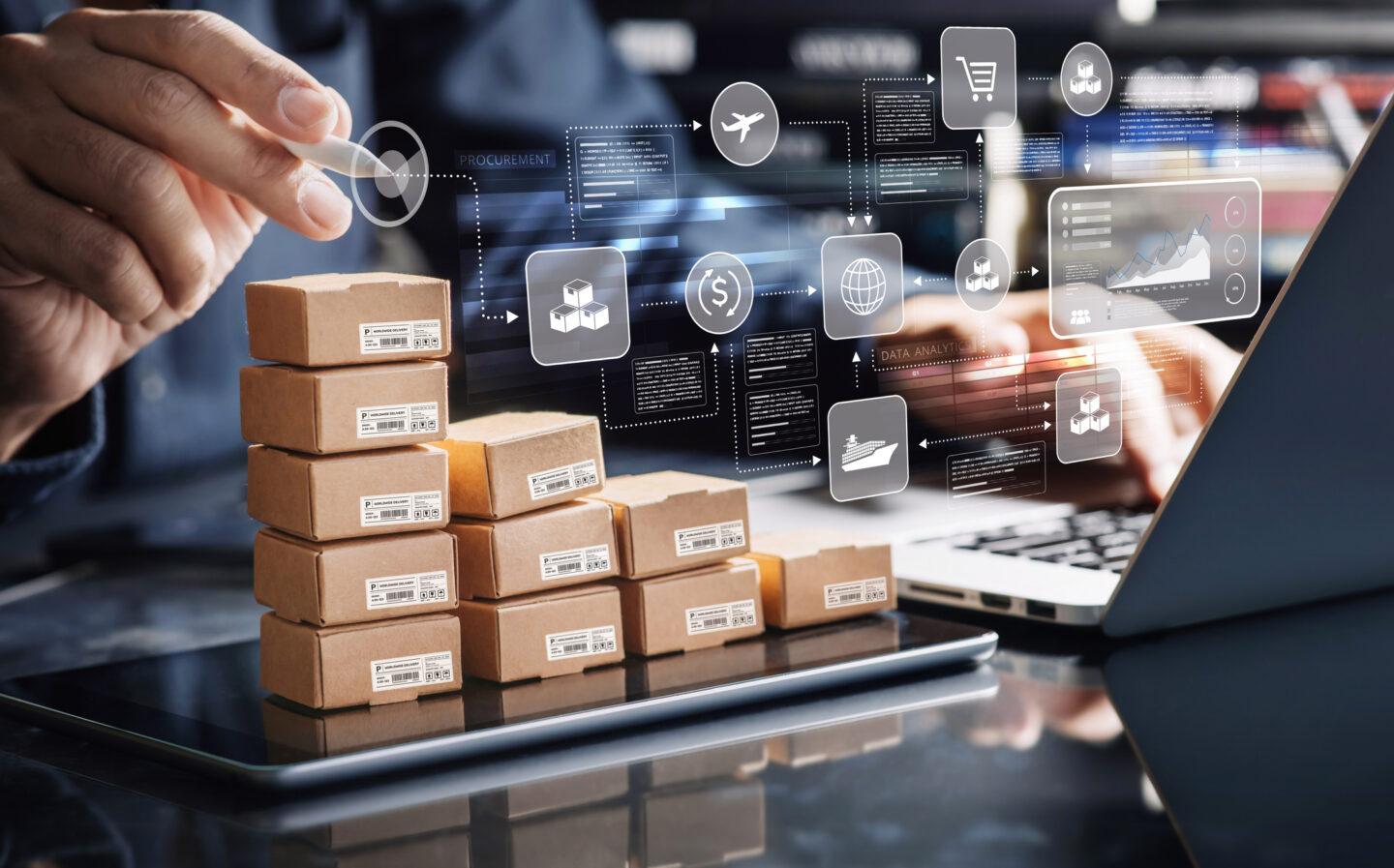 Na zdjęciu widać stos paczek w otoczeniu wykresów i analiz sprzedaży w e-commerce
