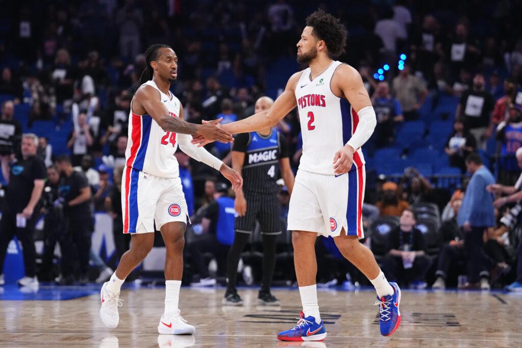 Dwóch koszykarzy Detroit Pistons podaje sobie rękę