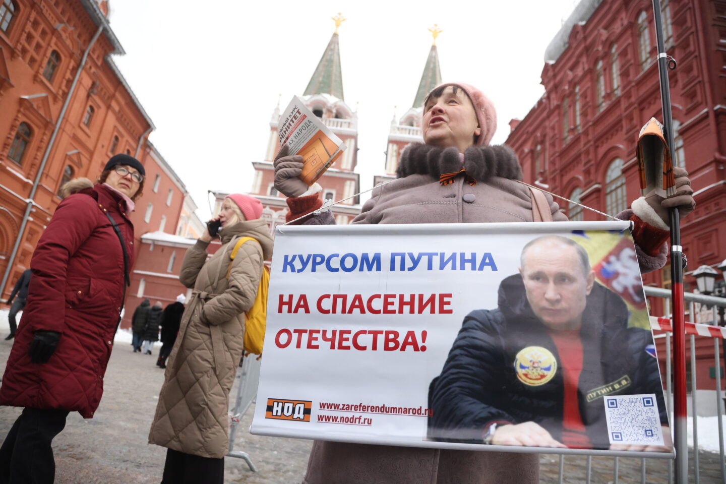 Członkini Ruchu Wyzwolenia Narodowego trzyma plakat poparcia dla prezydenta Rosji Władimira Putina na Placu Czerwonym w lutym 2024 r. w Moskwie, kilka tygodni przed wyznaczonymi na marzec wyborami prezydenckimi.