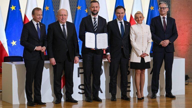 Od lewej: komisarz UE Piotr Serafin, komisarz UE Andrius Kubilius, szef MON Władysław Kosiniak-Kamysz, minister finansów Andrzej Domański, wiceprezes BGK Marta Postuła i prezes BGK Mirosław Czekaj podczas podpisania umowy pożyczkowej w ramach programu SAFE
