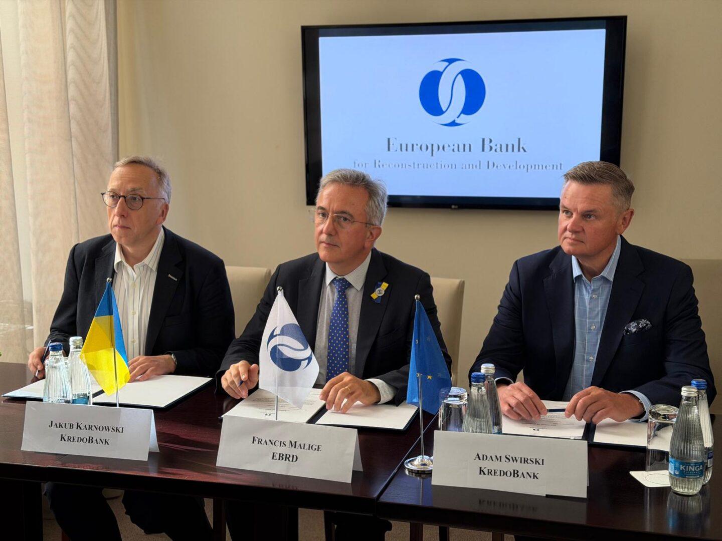 Prezes KredoBanku Jakub Karnowski, dyrektor zarządzający i szef grupy biznesowej instytucji finansowych w EBOR Francis Malige, wiceprezes zarządu KredoBanku Adam Świrski podczas podpisania umowy w trakcie URC 2026
