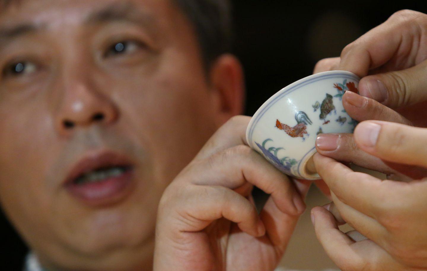 Chiński miliarder Liu Yiqian z wylicytowaną porcelanową czarką. Podczas procesu płatności inwestor postanowił zrobić użytek z wartego 137 mln zł naczynia i napił się z niego herbaty. W środowisku muzealnym gest ten odebrany został jako ryzykowna ostentacja.