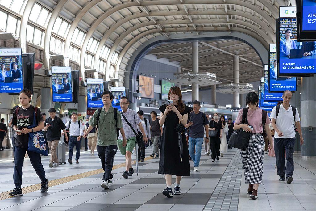 pasażerowie na japońskim dworcu