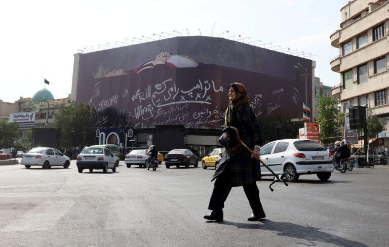 Teheran, kobieta na tle antytrumpowego billboardu, pokazującego prezydenta USA w trumnie