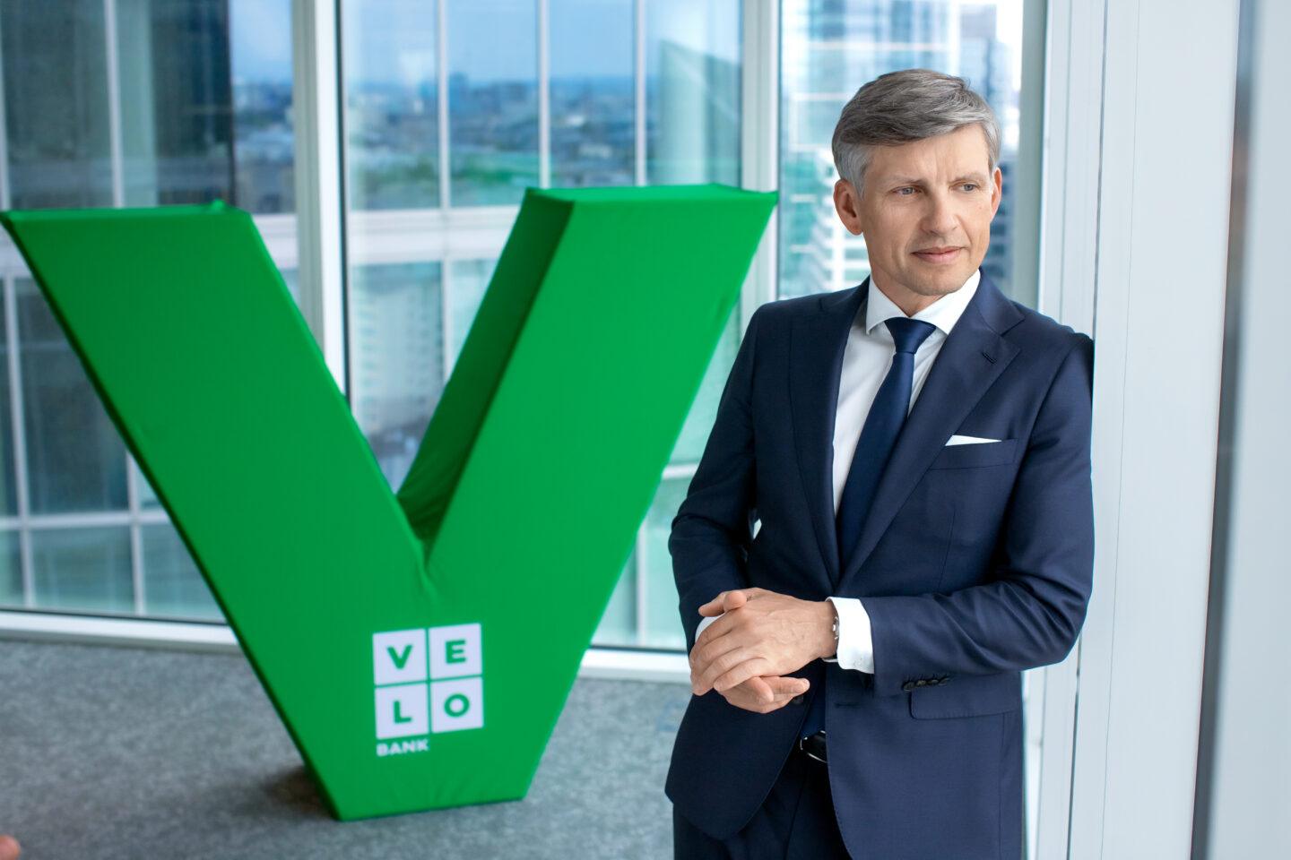 Adam Marciniak, prezes VeloBanku na tle logotypu firmy