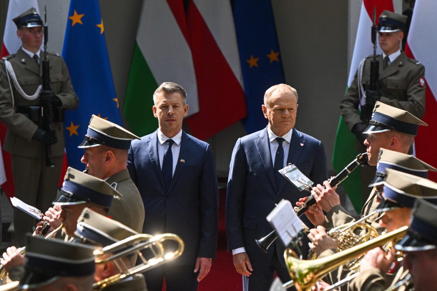 Premierzy Polski i Węgier – Donald Tusk i Péter Magyar – obserwują przemarsz orkiestry wojskowej w Warszawie.
